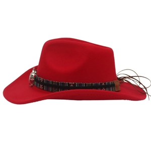 Detail of red wool felt cowboy hat with colorful woven band and silver skull buckle