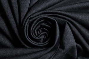 Close-up of black textile fabric texture showing smooth knit material and soft drape