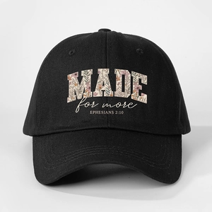 Close-up of black baseball cap with floral MADE for more text and Bible verse embroidery