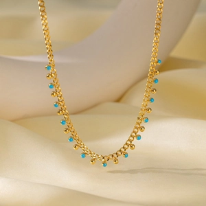 Minimalist gold titanium steel chain bracelet with vibrant blue stone beads on white display