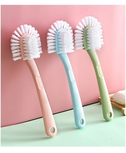 Three multi-functional plastic shoe brushes with long handles in pink, blue, and green