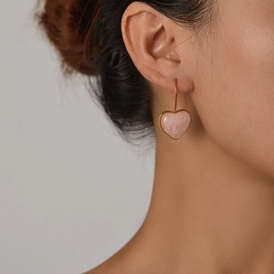 Elegant gold earrings with heart-shaped pink marble pendants for a minimalist look