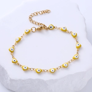 Detailed close-up of gold heart charms with blue evil eye enamel on adjustable chain