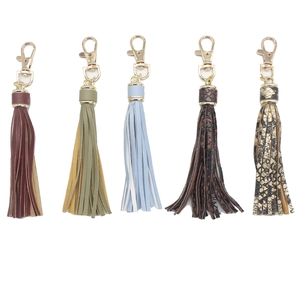 Five colorful PU leather tassel keychains with gold swivel lobster clasps on white background