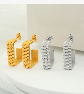 Detail of C-shaped hoop earrings with gold and silver presidential watch link texture