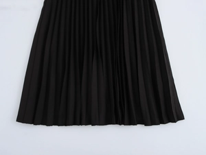 Detailed close-up showing the pleated texture and fabric of this black pleated skirt