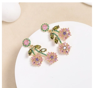 Macro shot of gold floral drop earrings with pink green and purple zircon crystals