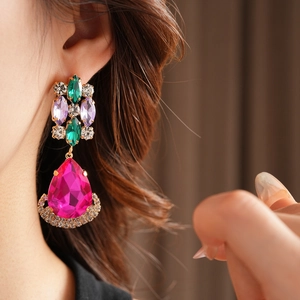 Close-up of vintage teardrop earrings with pink rhinestones and colorful crystals
