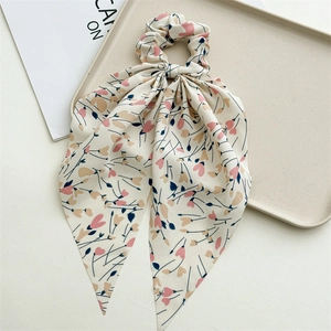 Detail of floral chiffon scrunchie with long ribbons in cream pink and yellow floral