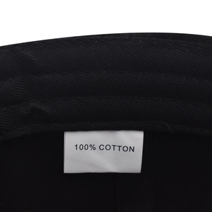 Detail shot of the 100% cotton fabric and washing label on a black baseball cap