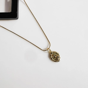 Detail of gold double-sided mermaid cameo pendant with elegant thin snake chain