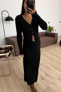 Dettaglio di un set in maglia a coste nere con cardigan scollo a V e gonna lunga