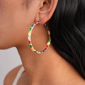 Golden large hoop earrings with rainbow rectangular zircon gemstones on model