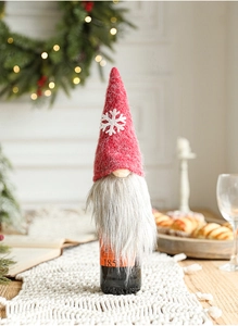 Close-up of plush gnome wine bottle cover with snowflake patterns and festive decor