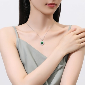 Elegant S925 silver necklace with oval emerald pendant and halo diamonds worn by a model