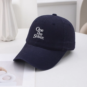 Close-up of One Day Sober white embroidery on dark blue cotton vintage baseball cap
