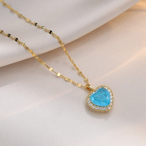 Titanium steel gold necklace with heart-shaped blue pendant and small white crystals