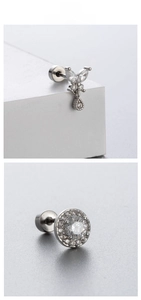 Macro detail of butterfly zircon earring and round crystal stud in titanium steel