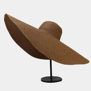 Detailed macro view showing the textured straw weave of the oversized sun hat