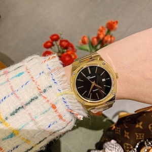 Fashionable gold quartz watch with black square dial and metal strap on woman's wrist