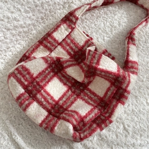 Detailed close-up of red and white checkered fleece texture on a large shoulder bag