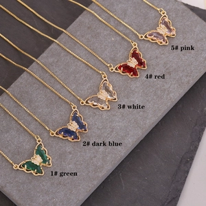 Detailed view of 18K gold butterfly pendant necklaces in five vibrant crystal colors