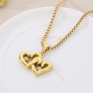 Close-up of 18K gold plated interlocking heart pendant necklace with small diamonds