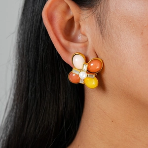 Gros plan de boucles d'oreilles fleur avec pierres colorées et perle sur mannequin