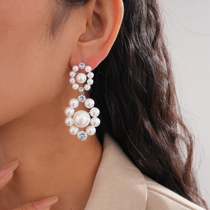 Close-up of elegant double halo pearl earrings with cubic zirconia on female model