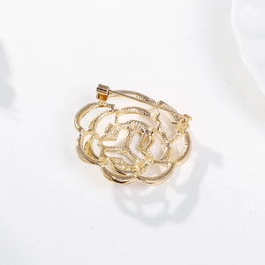 Back view of a gold rose brooch with sparkling crystals and a secure metal pin clasp
