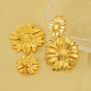 Detail of golden stainless steel sunflower earrings on silk with ice crystal decor