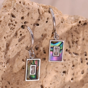 Macro detail of rectangle earring with natural abalone shell inlay and zircon on stone