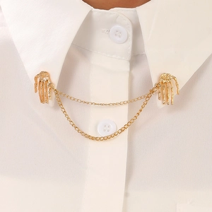 Macro shot of gold-plated skull hand collar pins with metal chains on white shirt