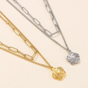 Detail of double-layer stainless steel necklace with hollow camellia flower pendant
