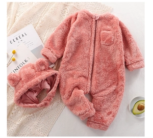 Close-up of plush pink baby jumpsuit with bear ear hat and front zipper detail