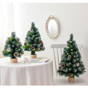 Three mini Christmas trees with snowy branches and pine cones on wooden bases