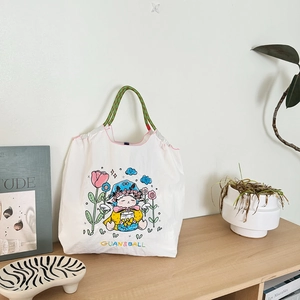 Detail of embroidered floral sheep pattern on white waterproof nylon shoulder bag