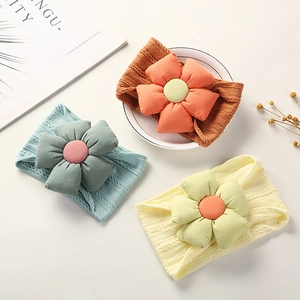 Detailed view of three soft jacquard nylon baby headbands with large flower accents