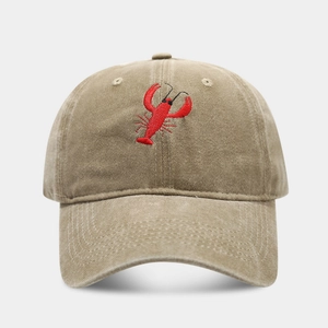 Close-up of vintage washed cotton fabric and detailed red lobster embroidery on cap