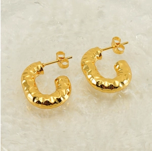 Macro shot of 18K gold-plated U-shaped earrings featuring a handcrafted hammered texture