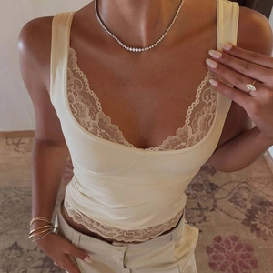 Gros plan sur la bordure en dentelle crème d'un caraco en satin col V pour femmes