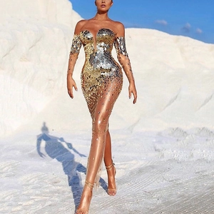 Elegant off-shoulder evening gown with gold sequins and sheer mesh panels in a desert setting