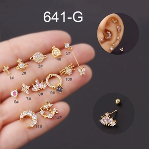 Detailed macro view of 12 gold titanium steel cartilage studs with zircon butterfly and saturn