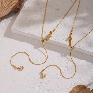 Minimalist double layer Y-shaped gold necklace with single diamond pendant on white stone