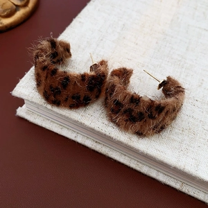Detailed macro view of plush leopard print C-shape hoop earrings with golden studs