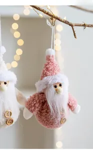 Close-up of handmade plush Santa ornaments in pink and beige with wooden buttons
