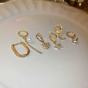 Gold plated star moon pearl earring set with zirconia heart pendants on white plate