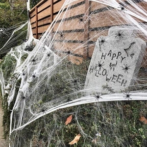 Outdoor Halloween decor set with white cobweb, black spiders, and a grey tombstone prop