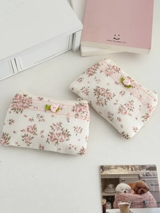 Détail de la trousse à maquillage florale avec bordure en dentelle et rose en soie