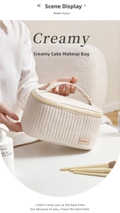 Close-up of cream PU leather makeup bag with vertical quilting and top handle